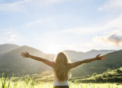 woman in nature with hands outstretched having a beautiful fresh morning